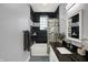 Bathroom with a tub and shower, black tile accent wall, and vanity with a granite countertop at 3535 Birchwood Ave, Indianapolis, IN 46205