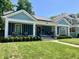 Attractive one-story home with metal roof, covered front porch, and lush green lawn at 3535 Birchwood Ave, Indianapolis, IN 46205