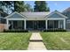 Charming single-story home featuring a metal roof, front porch, and well-manicured lawn at 3535 Birchwood Ave, Indianapolis, IN 46205
