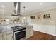 Kitchen featuring granite countertops, stainless steel range hood, and custom cabinetry at 3535 Birchwood Ave, Indianapolis, IN 46205
