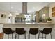Kitchen breakfast bar with granite countertops, seating for four, and a view into the modern kitchen at 3535 Birchwood Ave, Indianapolis, IN 46205