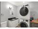 Modern laundry and powder room featuring stacked washer and dryer and a black granite vanity at 3535 Birchwood Ave, Indianapolis, IN 46205