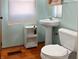Cozy bathroom with a pedestal sink, storage shelf, and light blue walls at 3540 N Norfolk St, Indianapolis, IN 46224