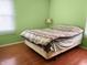 Simple bedroom with light green walls, hardwood floors, and a comfortable-looking bed at 3540 N Norfolk St, Indianapolis, IN 46224