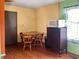 Cozy dining area with wood table, chairs and ample lighting. Microwave on top of dark wood dresser at 3540 N Norfolk St, Indianapolis, IN 46224