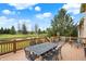 Inviting back deck with metal patio furniture overlooking a tranquil pond and lush greenery on a beautiful, sunny day at 3629 Pete Dye Blvd, Carmel, IN 46033
