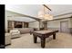 Spacious basement with pool table, seating, and built-in shelving at 3629 Pete Dye Blvd, Carmel, IN 46033