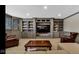 Finished basement with built-in shelving, large TV, comfortable seating, and neutral colored walls at 3629 Pete Dye Blvd, Carmel, IN 46033
