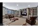 Finished basement with built-in shelving, large TV, comfortable seating, and neutral colored walls at 3629 Pete Dye Blvd, Carmel, IN 46033
