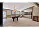 Expansive carpeted basement featuring a billiards table, seating area, and built-in shelving, perfect for entertaining at 3629 Pete Dye Blvd, Carmel, IN 46033