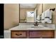 This warm bathroom features a wood vanity with marble countertop and bronze fixtures at 3629 Pete Dye Blvd, Carmel, IN 46033