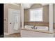 Large soaking tub is framed by columns and has a patterned window above and white doors to either side at 3629 Pete Dye Blvd, Carmel, IN 46033