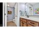 This bathroom features a wood vanity with a marble countertop, unique art, and a nearby toilet at 3629 Pete Dye Blvd, Carmel, IN 46033