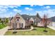 Stunning brick home featuring professional landscaping, a gray roof and an attached three car garage at 3629 Pete Dye Blvd, Carmel, IN 46033