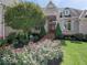 Charming brick home entrance featuring manicured garden beds with blooming flowers at 3629 Pete Dye Blvd, Carmel, IN 46033