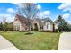 Beautiful brick home with manicured lawn, mature trees, and a charming entrance walkway at 3629 Pete Dye Blvd, Carmel, IN 46033