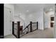 Bright hallway with carpeted floor, dark wood and iron railing, and neutral paint tones at 3629 Pete Dye Blvd, Carmel, IN 46033