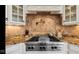 Detailed shot of a kitchen featuring a professional-grade range, custom backsplash, and granite countertops at 3629 Pete Dye Blvd, Carmel, IN 46033