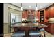 Cherry-stained kitchenette boasts granite countertops, stainless steel refrigerator, and custom cabinets for wine storage at 3629 Pete Dye Blvd, Carmel, IN 46033