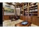 Stately office with custom wood bookshelves, wainscoting, a large desk, and a cozy seating area at 3629 Pete Dye Blvd, Carmel, IN 46033