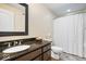 Bathroom with a dark granite sink, cabinet and shower/tub with curtain at 368 Westbrook Ct, Columbus, IN 47201