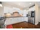 A well-appointed kitchen showcasing white cabinetry, stainless steel appliances, a brick backsplash, and hardwood flooring at 368 Westbrook Ct, Columbus, IN 47201