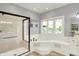 Bright bathroom boasts a glass shower, soaking tub, and a large window with a view to the backyard at 3862 Penzance Pl, Carmel, IN 46032
