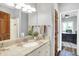 Bright bathroom features granite countertops, white cabinetry, and a doorway to the office area at 3862 Penzance Pl, Carmel, IN 46032