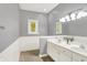 Bathroom features double vanity, neutral paint, large mirror, and natural light from the window at 3862 Penzance Pl, Carmel, IN 46032