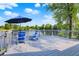 A spacious backyard deck overlooking a calm pond, with scenic views and two Adirondack chairs at 3862 Penzance Pl, Carmel, IN 46032