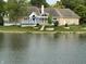 Picturesque backyard view featuring a deck, a manicured lawn, and a serene pond, creating an inviting outdoor retreat at 3862 Penzance Pl, Carmel, IN 46032