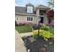 Close up of a home's front yard with lush flower beds and manicured lawn at 3862 Penzance Pl, Carmel, IN 46032