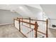 The hallway overlooks the rooms below, featuring natural lighting and wooden railings at 3862 Penzance Pl, Carmel, IN 46032