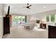 Large bedroom with lake views from french doors, neutral carpet, ceiling fan, and ensuite bathroom at 3862 Penzance Pl, Carmel, IN 46032