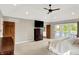 Spacious bedroom with a private balcony overlooking the lake, ceiling fan, ensuite bathroom, and neutral carpet at 3862 Penzance Pl, Carmel, IN 46032