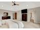Spacious bedroom with ensuite bathroom, ceiling fan, and neutral carpet at 3862 Penzance Pl, Carmel, IN 46032