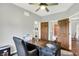 Well lit office with a ceiling fan, a dark wood executive desk, and a view of an open paneled door at 3862 Penzance Pl, Carmel, IN 46032