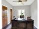 Traditional office with a dark wood executive desk, ceiling fan and two wood paneled doors at 3862 Penzance Pl, Carmel, IN 46032