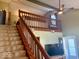 Staircase to upper level overlooks living room, with view of ceiling fan and natural light at 3934 N Lakeside Dr, Muncie, IN 47304