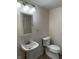 Compact bathroom with a pedestal sink, a toilet, and a mirrored medicine cabinet at 418 N Drexel Ave, Indianapolis, IN 46201