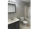 A well-lit bathroom with a gray vanity, toilet and shower with a shower curtain at 418 N Drexel Ave, Indianapolis, IN 46201