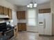 Traditional kitchen with wooden cabinets, black appliances, and a double-door refrigerator at 418 N Drexel Ave, Indianapolis, IN 46201