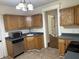 Kitchen featuring wooden cabinets, stainless steel appliances, and a sink with modern faucet at 418 N Drexel Ave, Indianapolis, IN 46201