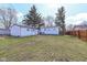 Spacious backyard with grass, trees, a detached garage, and a wooden fence at 4414 Lexington Ave, Indianapolis, IN 46203