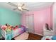 Charming bedroom features blue and pink walls, wood floors, ceiling fan, and whimsical decor at 4414 Lexington Ave, Indianapolis, IN 46203