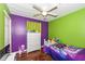 Vibrant bedroom with purple and green walls, wood floors, and fun decor at 4414 Lexington Ave, Indianapolis, IN 46203