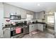 Well-lit kitchen with stainless steel appliances, gray cabinets, and dining area view at 4414 Lexington Ave, Indianapolis, IN 46203