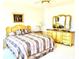 Comfortable bedroom with neutral colors, a large dresser with mirrors, and a ceiling fan at 4414 Princeton Park Dr, Columbus, IN 47201