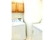 A functional laundry room features white appliances and wooden cabinets at 4414 Princeton Park Dr, Columbus, IN 47201