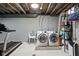 Unfinished basement laundry features a utility sink, washer, dryer, and metal shelving at 4850 Guilford Ave, Indianapolis, IN 46205